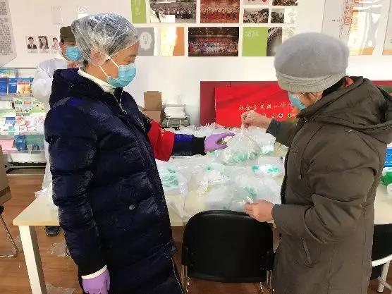 為樓棟分發(fā)口罩，并為包裝袋消毒